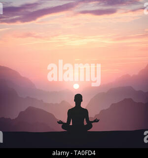 L'uomo meditando di alta montagna in background al tramonto Foto Stock