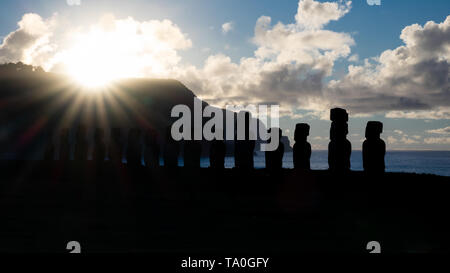Stella luminosa il sorgere del sole dietro il moai sagome in Isola di Pasqua Foto Stock