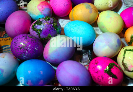 Un assortimento di colorate e decorate uova asciugatura sul giornale. Foto Stock