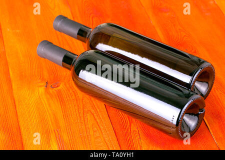 Bottiglie di vetro di vino rosso sul tavolo di legno sfondo Foto Stock