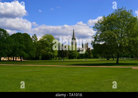 Il bellissimo e tipico paesaggio del Regno Unito. Erba verde e gli alberi del parco in una giornata di sole con cielo blu e nuvole soffici. Foto Stock