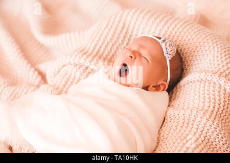 Sbadigliare bambina giacente in letto vicino. Buona mattina. Infanzia. Foto Stock