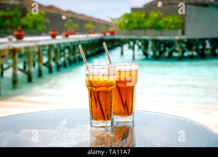 Tè freddo contro tropical Overwater Bungalow Resort sulla spiaggia. Maldive. Foto Stock