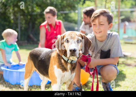 Ragazzo giovane petting cane in animal shelter Foto Stock