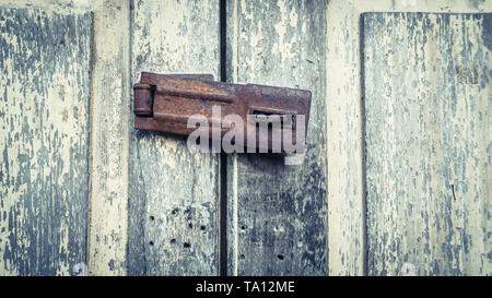 Vintage macchia rustico Vecchia serratura macchia linea U Hasp fiocco temprato equipaggiamento su legno verniciato porta. Vecchia serratura sulla porta, serratura sulla porta di un vecchio lontano Foto Stock