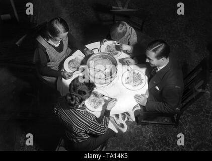 Immagine simbolica di Nazi-propaganda sulla Eintopf Sonntag (stufato domenica) programma della Winter rilievo: la famiglia quando mangiare. Non datata (foto) Foto Stock