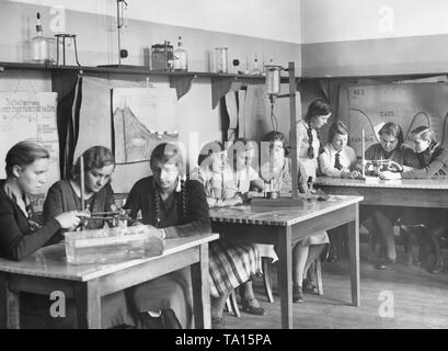 Cercare in una classe durante una classe di fisica a una ragazza della scuola secondaria in Neukoelln. La foto è stata scattata in occasione del XXV anniversario della scuola, probabilmente nel 1932. Foto Stock