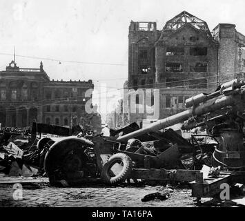 La Potsdamer Platz a Berlino dopo la cattura della città da parte dell'Armata Rossa. Sulla destra un distrutto 8.8 cm FlaK 18/36/37, che fino a poco tempo fa, è stato utilizzato nella lotta contro i carri armati sovietici. Sullo sfondo di un gruppo di civili di fronte russo di segnaletica stradale. Foto Stock