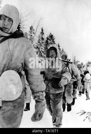 I soldati tedeschi marzo attraverso una coperta di neve campo durante l'inverno battaglie difensive sul fronte orientale. Foto di Propaganda Company (PK): corrispondente di guerra Wacker. Foto Stock