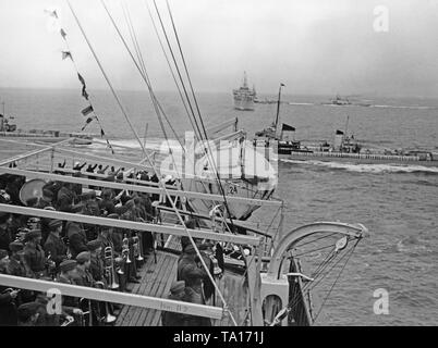 Foto di una banda militare della Legione Condor sul ponte della Kraft durch Freude ('Sforzo attraverso Gioia") vaporizzatore, "Robert Ley', fuori dell'isola di Borkum nel Mare del Nord il 30 maggio 1939. In background, un altro passeggero vapore del KdF flotta. Le navi sono accolti dall'incrociatore tedesco 'Admiral Graf Spee' (Germania) di classe e il suo squadrone. Foto Stock