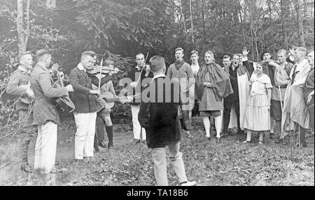 Gli studenti di un campo di lavoro per trascorrere la serata insieme e di rendere la musica in una foresta. Foto Stock