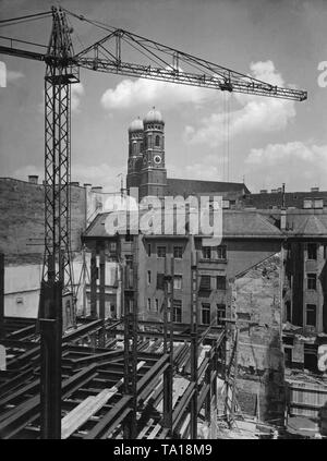 Lavori di costruzione della costruzione di Knorr & Hirth Verlag (predecessore della Sueddeutsche Verlag) sulla zona tra Sendlinger Strasse e Faerbergraben a Monaco di Baviera, sullo sfondo la Frauenkirche. Foto Stock