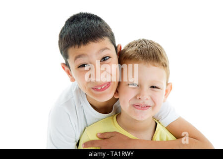 Due felice e gioiosa di amare i fratelli isolati su sfondo bianco.Smilling in telecamera.quattro anni e nove anni Foto Stock