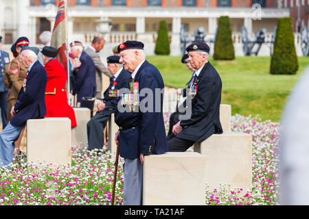 La Normandia reduci presenti presso il D-Day 75 giardino, seduti su 15 plinti in pietra che faccia John Everiss' sculture dei soldati sulle spiagge Foto Stock