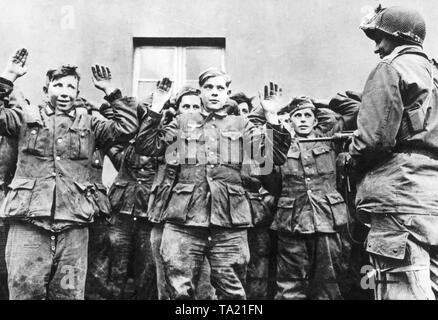 I giovani prigionieri di guerra tedeschi, sorvegliato da un soldato americano. La foto è stata scattata durante la Battaglia di Remagen. Foto Stock