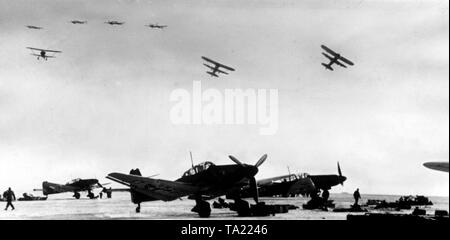 Mentre Junkers Ju 87 dive bombardieri vengono preparati per la loro missione nella zona di manovra, uno squadrone di Henschel Hs 123 è già in azione. Foto di Propaganda Company (PK): corrispondente di guerra Bischhaus. Foto Stock