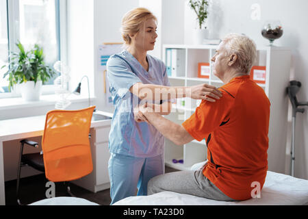 Bella giovane donna che mantiene la sua mano di pazienti Foto Stock