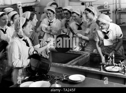 Membri del BDM vengono addestrati in aiuto domestico durante il loro Landjahr. Qui, le ragazze sono lavando i piatti in cucina in una competizione professionale. Foto Stock
