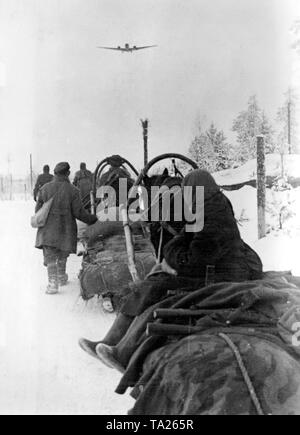 I soldati tedeschi su Panja slittini su di una via a Demjankst. Al di sopra di un JU 52 battenti. Foto di Propaganda Company (PK): corrispondente di guerra Beissel. Foto Stock