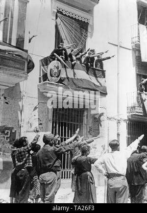 Foto degli abitatori di Castellon de la Plana, Valencia, Spagna, la sera del 13 giugno 1936, quando le truppe di Franco invasero la capitale provinciale dopo pesanti combattimenti. Su strada e da un balcone contrassegnati, gli abitanti dare ai soldati il saluto fascista. Sul balcone, lo stemma di un consolato della Bolivia. Foto Stock