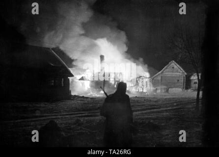 Un soldato tedesco di notte davanti a un ardente villaggio russo a ovest di Mosca. (PK-foto) Foto Stock