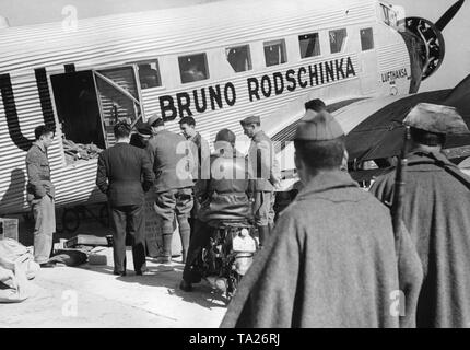 Foto di un Tedesco Junkers Ju 52 di Deutsche Lufthansa AG 1939 a Salamanca airport, Castiglia e Leon, Spagna. Il velivolo porta il nome di "Bruno Rodschinka '. Si tratta solo di essere caricato. In primo piano due poliziotti della Guardia Civil. Foto Stock