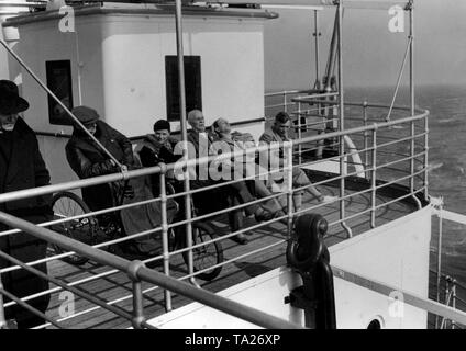 Sono i vacanzieri che si diverte a bordo di una nave da crociera dell'organizzazione nazista "Kraft durch Freude' ('Sforzo attraverso Gioia") durante un viaggio per mare a Madera. Un utente su sedia a rotelle è tra di loro. Foto Stock