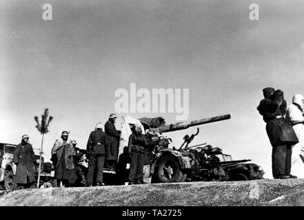 Granatieri di una unità SS guarda la parte anteriore da una collina. Un 8.8 cm FlaK è usato da loro per target di massa.Essi sono in parte dotate di abbigliamento invernale. (SS-Foto di Propaganda Company (PK): corrispondente di guerra Neumann) Foto Stock