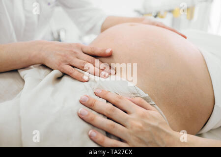 Medico donna esame dello stomaco in gravidanza, close-up la gravidanza Foto Stock