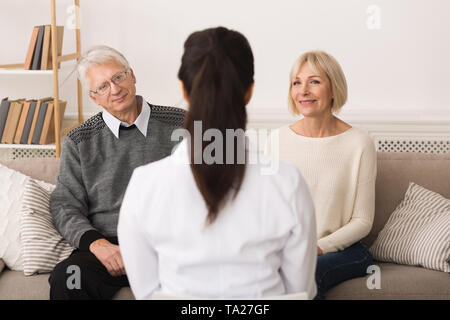 Medico donna visitando Coppia senior, parlando con loro Foto Stock