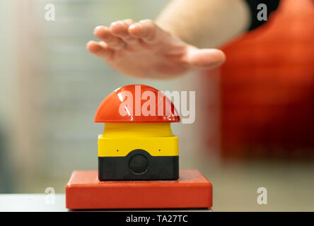 Lavoratore ha per premere il pulsante di arresto di emergenza veloce. Foto Stock