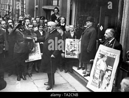 Presidente del Reich, Paul von Hindenburg, lascia la stazione di polling dopo la fusione il suo voto in occasione della stato prussiano elezioni. I poliziotti sono salutando. I sostenitori della campagna di parti con manifesti elettorali: "Costruiamo !", dichiara il poster del NSDAP. Foto Stock