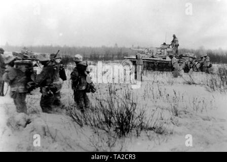 I soldati tedeschi attraversano una coperta di neve settore sud-est della città di Toropez. La fanteria sono supportati da serbatoi (compreso un Panzer IV). Foto di Propaganda Company (PK): SS corrispondente di guerra ciuffi. Foto Stock