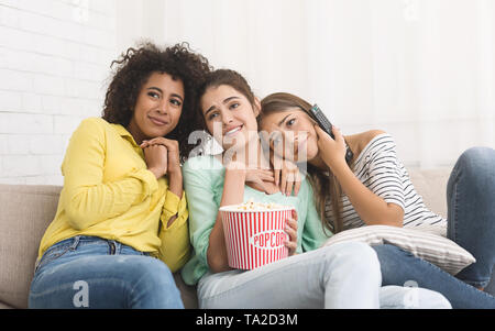 Coinquilini guardando film con tenera emozione a casa Foto Stock