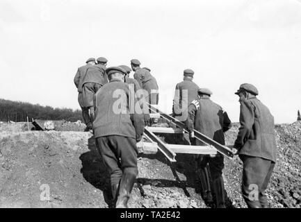 Membri del freiwilliger Arbeitsdienst - Volontariato Servizio (FAD) portano un tratto di linea ferroviaria a una posizione elevata (Foto non datata). Foto Stock