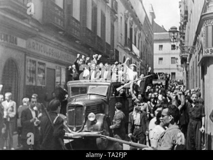 Foto di allegra repubblicano volontari combattenti del fronte dei popoli e dei lavoratori le milizie che viaggiano su un camion attraverso una città in Catalogna, Spagna. Nei giorni dopo lo scoppio della guerra civile, molti presidi dell esercito hanno aderito all'putschists sotto il generale Franco. Dopo lo scoppio della guerra civile il 17 giugno 1936, molte città in Spagna sono state teatro di combattimenti di strada tra i repubblicani, i comunisti e i nazionalisti. Foto Stock