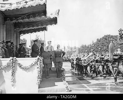 Foto di una banda militare della Legione Condor con una mezzaluna turca marciando nella parte anteriore di ufficiali della Wehrmacht e leader Adolf Hitler (sotto una tettoia) in parata per la Legione Condor sull'asse est-ovest (ex Chalottenburger Chaussee, oggi Strasse des 17. Juni) nella parte anteriore della Technische Universitaet il 6 giugno, 1939. Da destra a sinistra: il maggiore generale Wolfram Freiherr von Richthofen, General der Flieger Hugo Sperrle e Maresciallo di Campo generale Hermann Goering. Sullo sfondo il Grandhotel Am Knie (oggi, Ernst Reuter Platz). Foto Stock