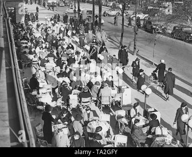 Il primo Café Kranzler a Berlino è stato aperto nel 1825 da Johann Georg Kranzler come una piccola pasticceria in strada "Unter den Linden" nel distretto Mitte di Berlino. Nel 1932 aprì il secondo ramo dell'ex Café des Westens sotto il nome di 'Restaurant und Konditorei Kranzler' in la Joachimstaler Strasse (oggi Joachimsthaler Strasse) nel quartiere Charlottenburg. Entrambi gli edifici sono stati distrutti durante i raid aerei negli anni 1944 e 1945. La foto mostra la strada terrazza, il cosiddetto "rampe", con alcuni ospiti. Foto Stock