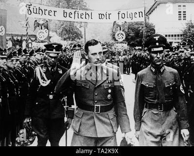 Albert Forster, il Gauleiter nazista di Danzica, (medio) prende la salute dei membri delle SS-Heimwehr Gdansk, SS-Wachsturmbann Eimann durante una riunione di distretto leader della NSDAP nella città libera di Danzica. Su un banner si erge lo slogan: 'Fuehrer befiehl-wir folgen!" ("il Fuehrer comandi, seguiamo'), dietro di esso la sovranità nazista simboli del Reich tedesco. Foto Stock