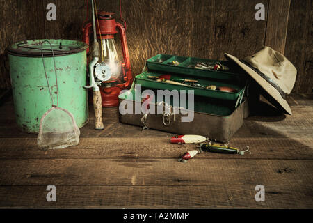 Vintage canna da pesca e delle attrezzature e la lanterna su grungy superficie di legno Foto Stock