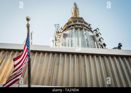 Vista della sommità dell'Empire State Building con il flag di noi su un NYC il blu del cielo della sera Foto Stock