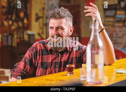 Bar rilassante per avere bere e rilassarsi. Uomo con barba trascorrere il tempo libero a bere alcol forte. Bere per divertimento. Brutale parigamba uomo barbuto sedersi al banco bar. Venerdì sera. Hipster rilassante presso il bar. Foto Stock