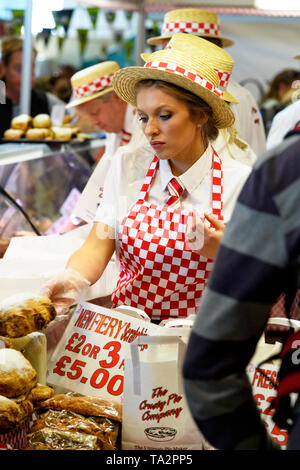 Persone (indossando Red & White) lavorando, display di pasties & torte & i potenziali clienti - Torta croccante di stallo, grande spettacolo dello Yorkshire, Harrogate, England, Regno Unito Foto Stock