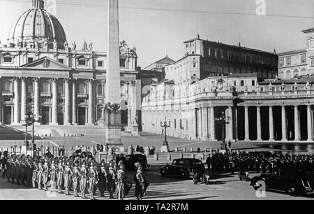 Visitare il sito web italiano della coppia reale in Vaticano dopo la conclusione del Trattato Lateranense, conclusosi il 60 anno di conflitto tra la Chiesa e lo stato italiano. Nella foto l'arrivo della colonna di auto della sentenza giovane nella Città del Vaticano. La Guardia Svizzera costituisce una guardia d'onore. Foto Stock