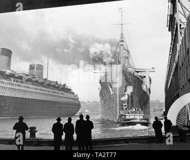 La regina Maria' Lascia New York. Come un vettore di truppa, il British luxury liner navigato a Città del Capo e Sidney per espandere il fronte del Pacifico. Sul lato sinistro della banchina giace il francese ocean liner "Normandie". Foto Stock