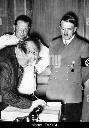 Il Primo ministro francese Edouard Daladier Firma il guestbook durante la conferenza di Monaco sulla Sudeti crisi, in presenza di Hermann Goering (sinistra) e Adolf Hitler (a destra), Foto Stock