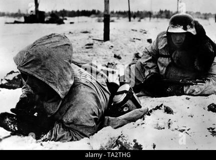 Due Waffen-SS uomini prendere il coperchio dal nemico missili. Presumibilmente, si trovano a sud del lago Ladoga nella sezione nord del Fronte Orientale. Foto di Propaganda Company (PK): corrispondente di guerra Raudies. Foto Stock