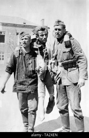 Due soldati tedeschi portano un prigioniero francese della guerra alla stazione di medicazione. Foto: il Brennero. Foto Stock