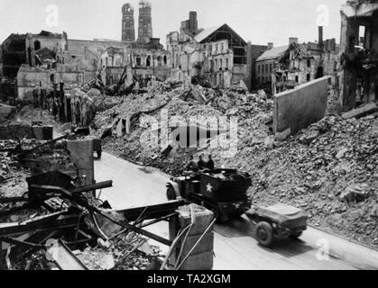 Un americano a mezza via il veicolo del tipo "M15 Semicingolato' rispettivamente 'M15 Combinazione Gun Carrello motore' ride attraverso il Monaco di Baviera Theatinerstrasse. Sullo sfondo le torri della Frauenkirche. Foto Stock