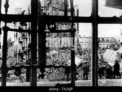 Vista dei detriti attraverso barre in downtown Orel (Orjol). I civili di ricerca in macerie per pezzi utilizzabili. Presumibilmente, questa foto è stata scattata poco prima della riconquista della città da parte delle truppe sovietiche, alla fine di luglio o ai primi di agosto, 1943. Foto Stock